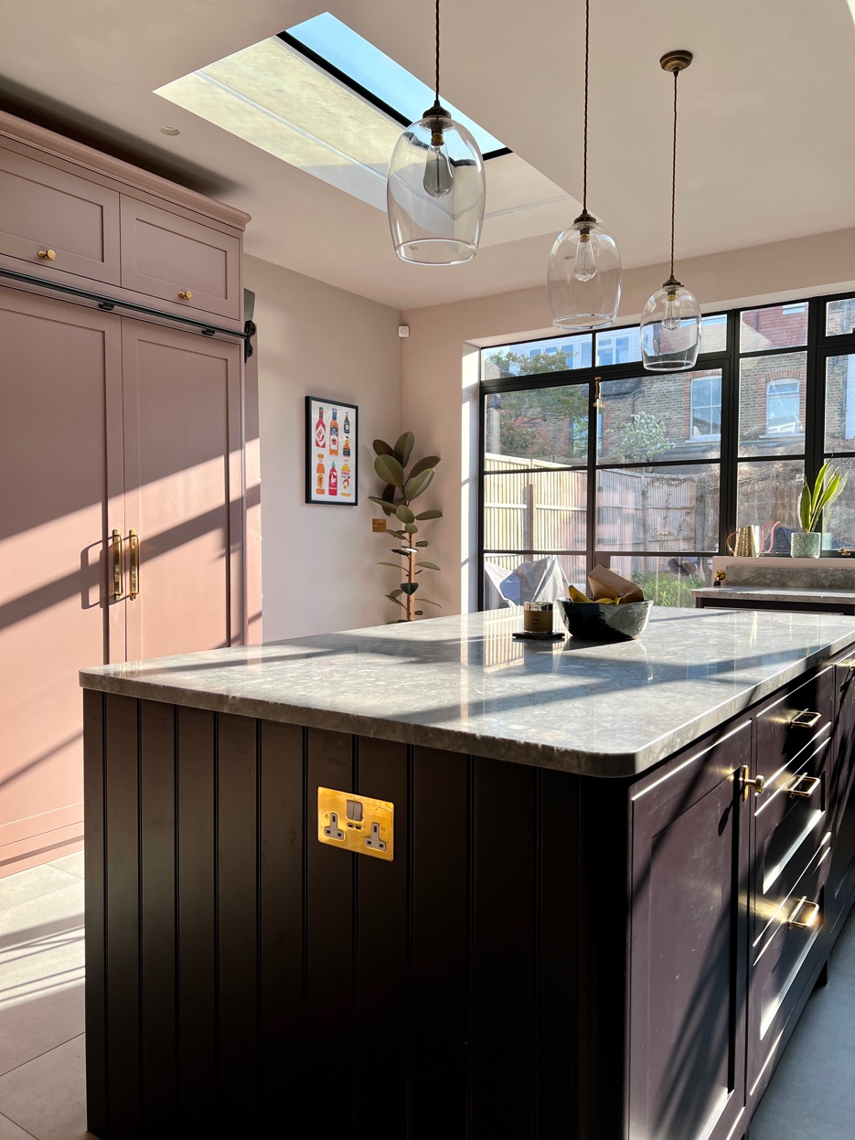 Kitchen island detail showing reeded panel, quartzite worktop, and pendant lights